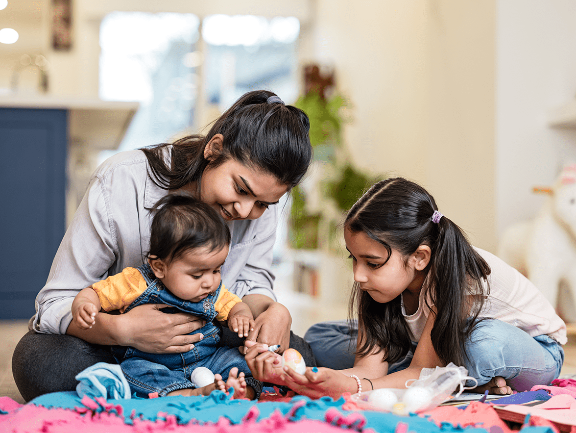 Caregiver playing with baby and child