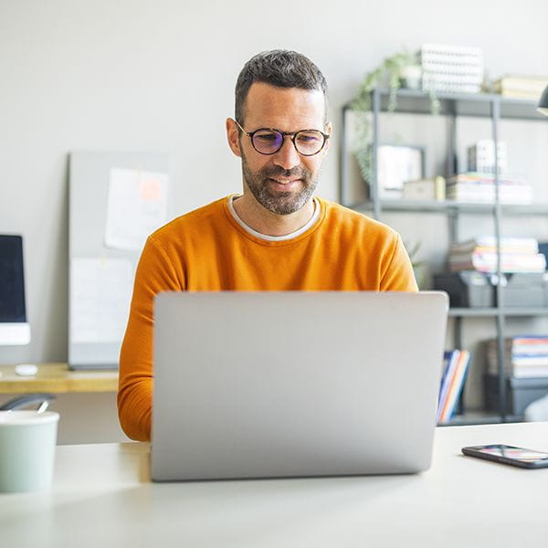 Man working on his laptop while sitting at a table