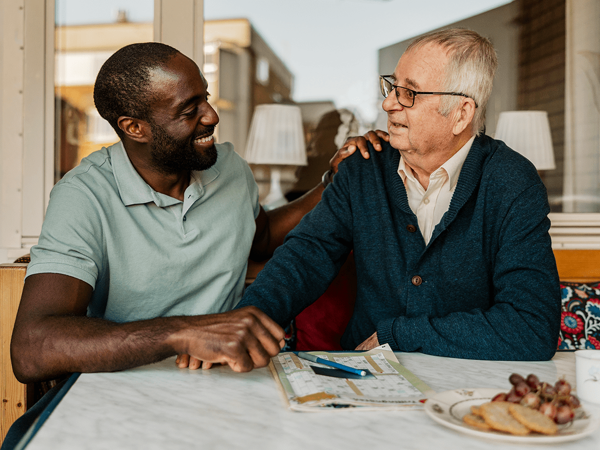 Elder sitting at a table with caregiver