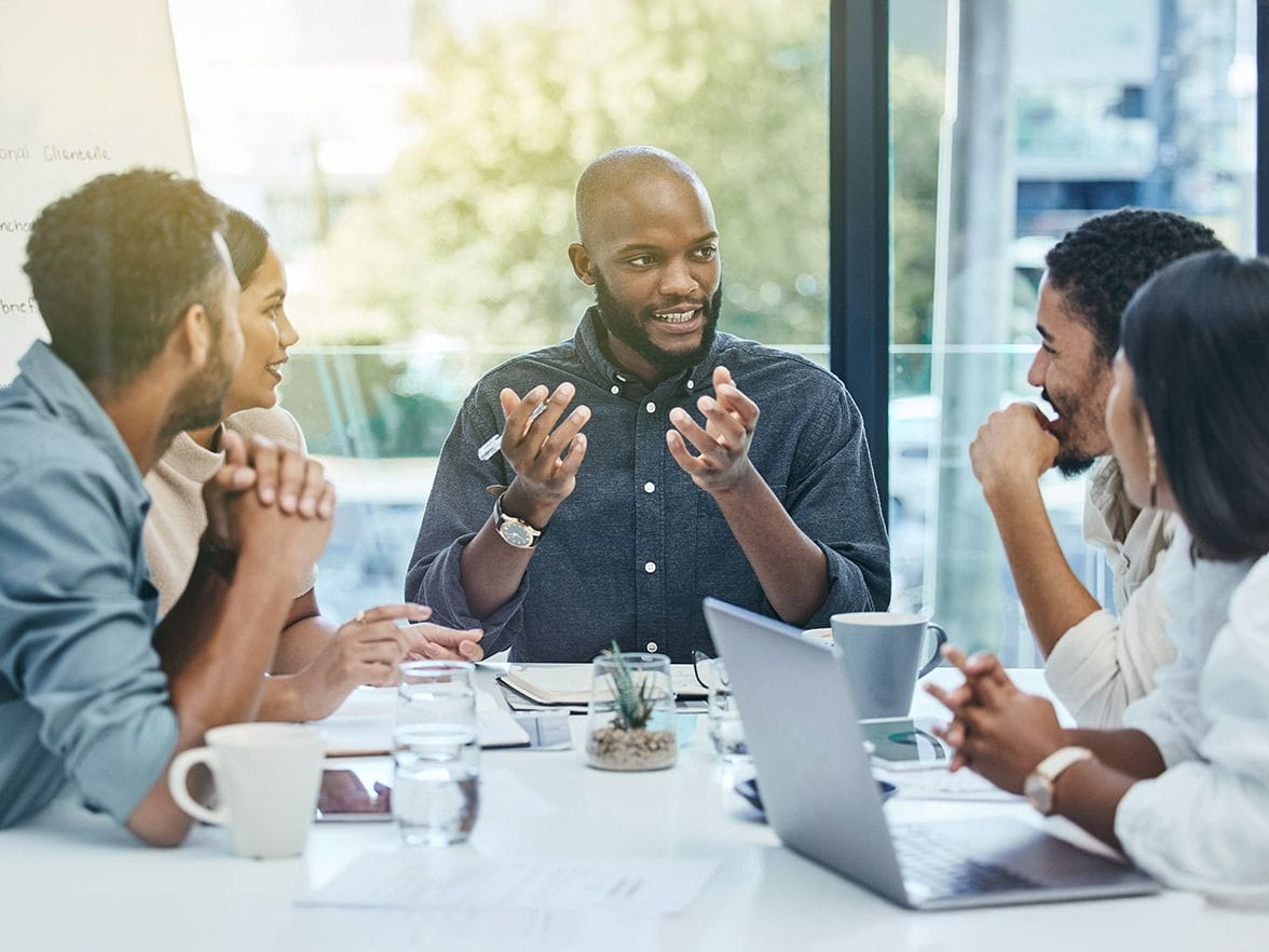 Coworkers sitting at a table discussing a topic