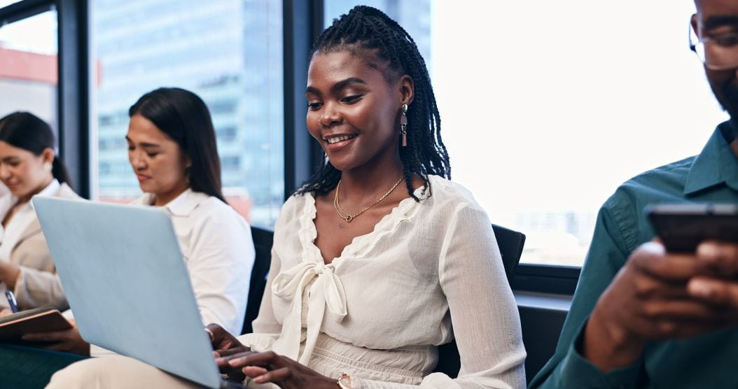 Adult woman in a classroom setting holding a laptop