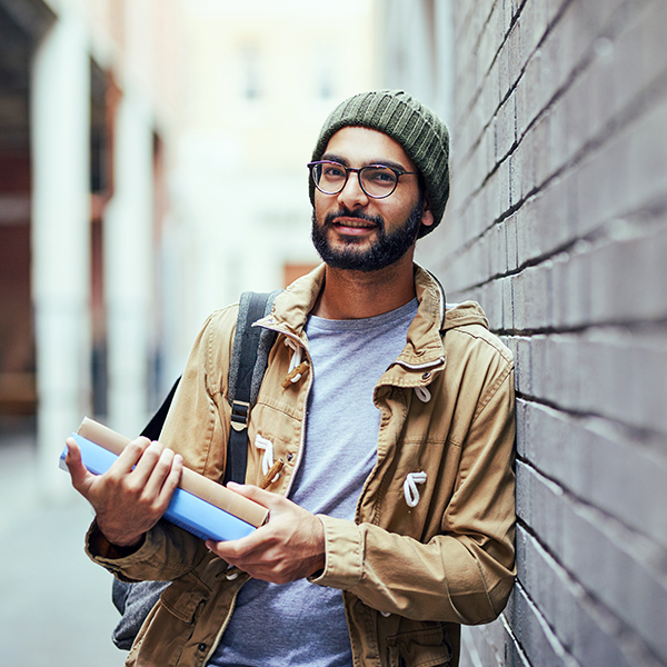 Young professional walks from work to school with text books