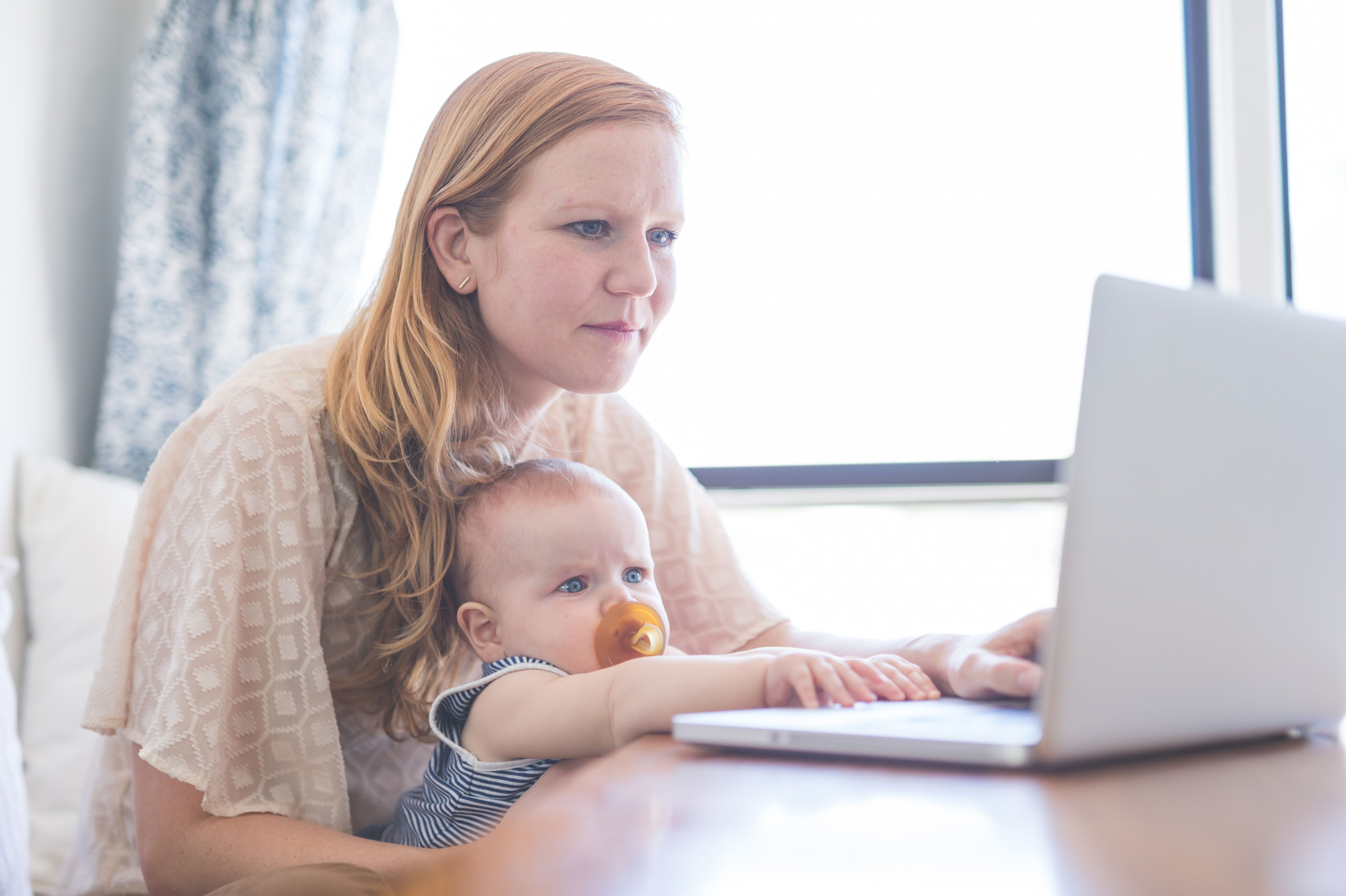 woman and baby looking at computer