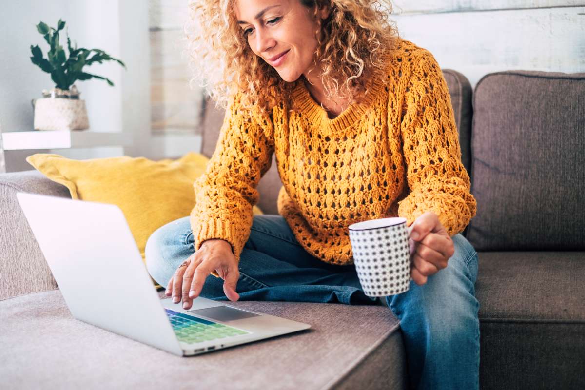 woman working on laptop while drinking coffee