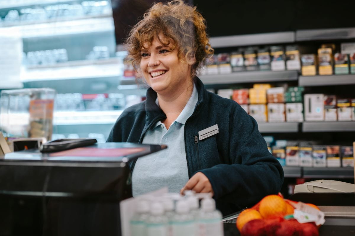 grocery store cashier smiling at check out