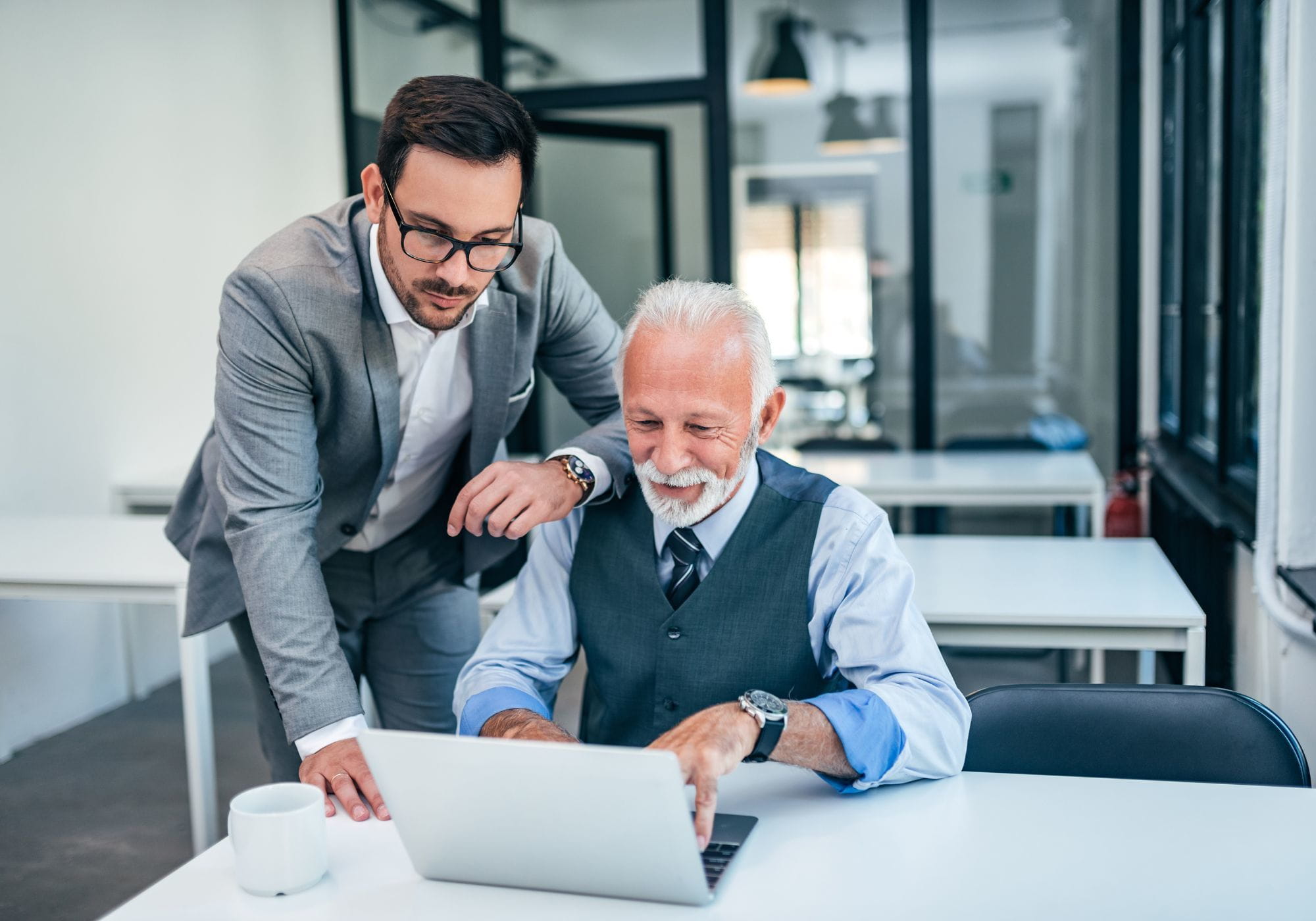 two men working together on laptop