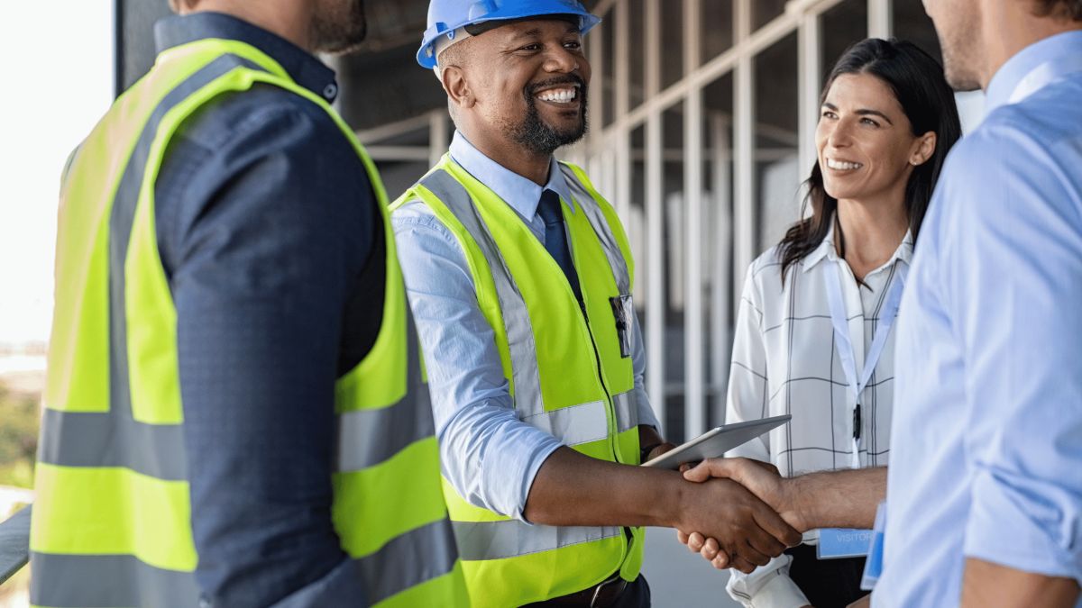 business professionals shaking hands on construction job site