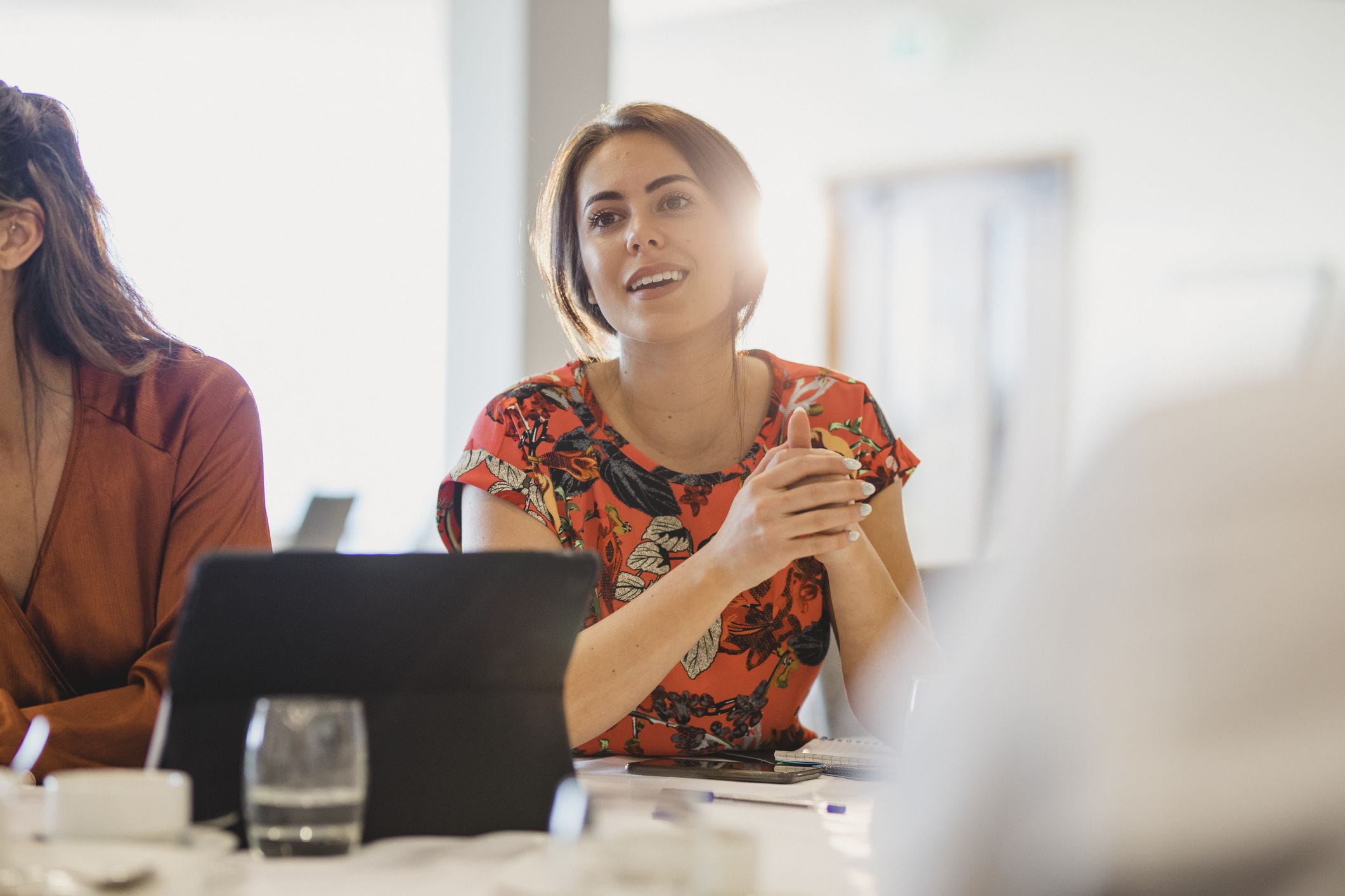 Woman in red shirt talking in meeting