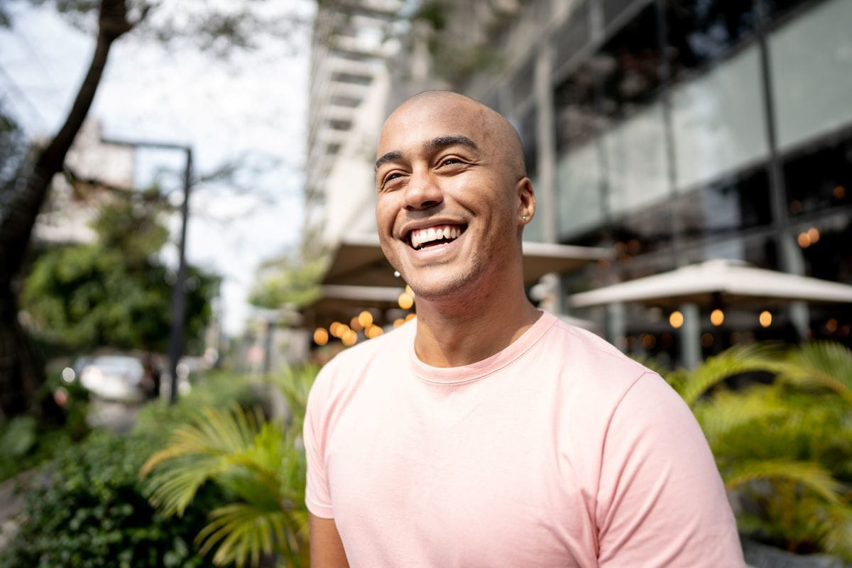 man smiling outside of office building