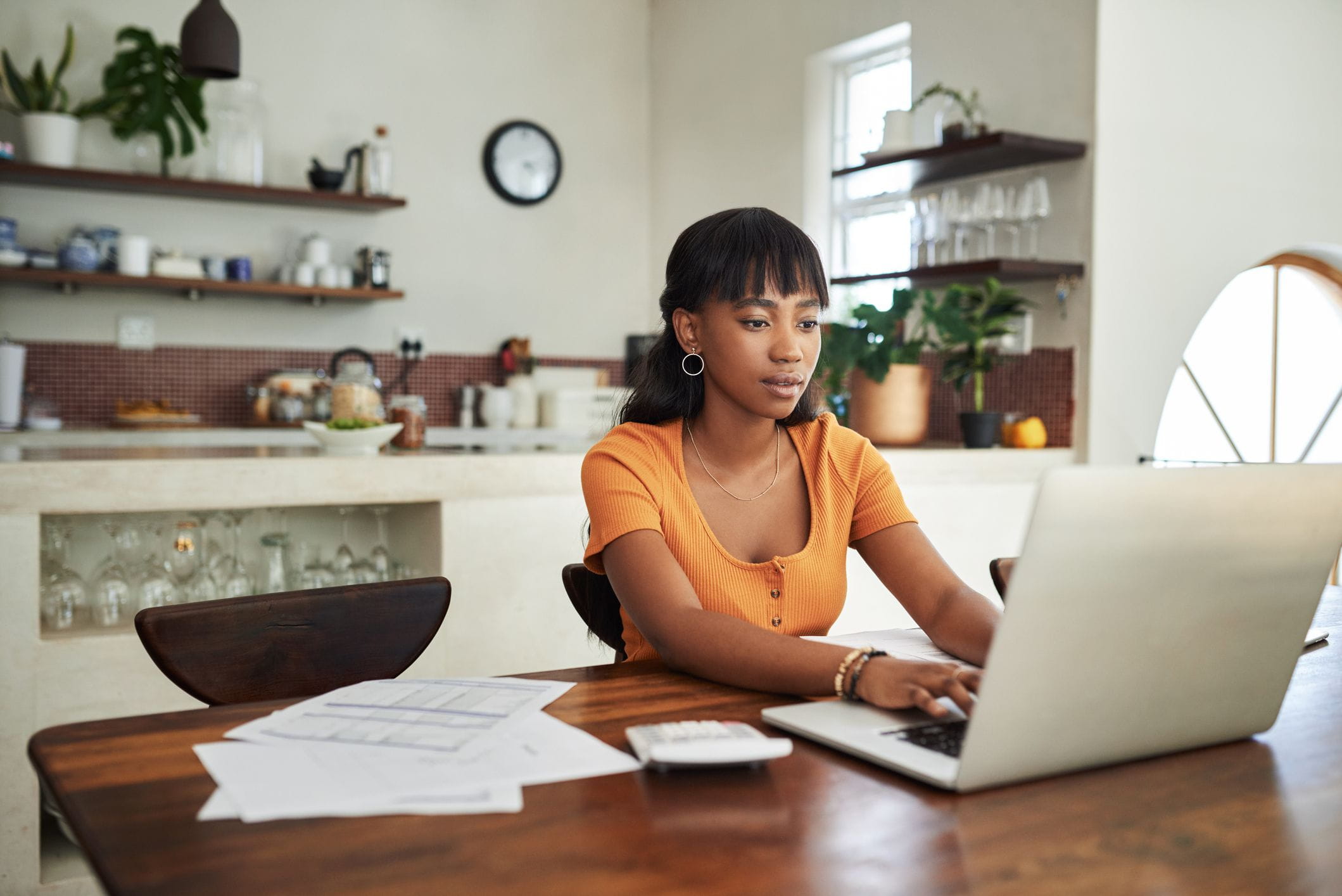 Woman sitting at a computer with paperwork