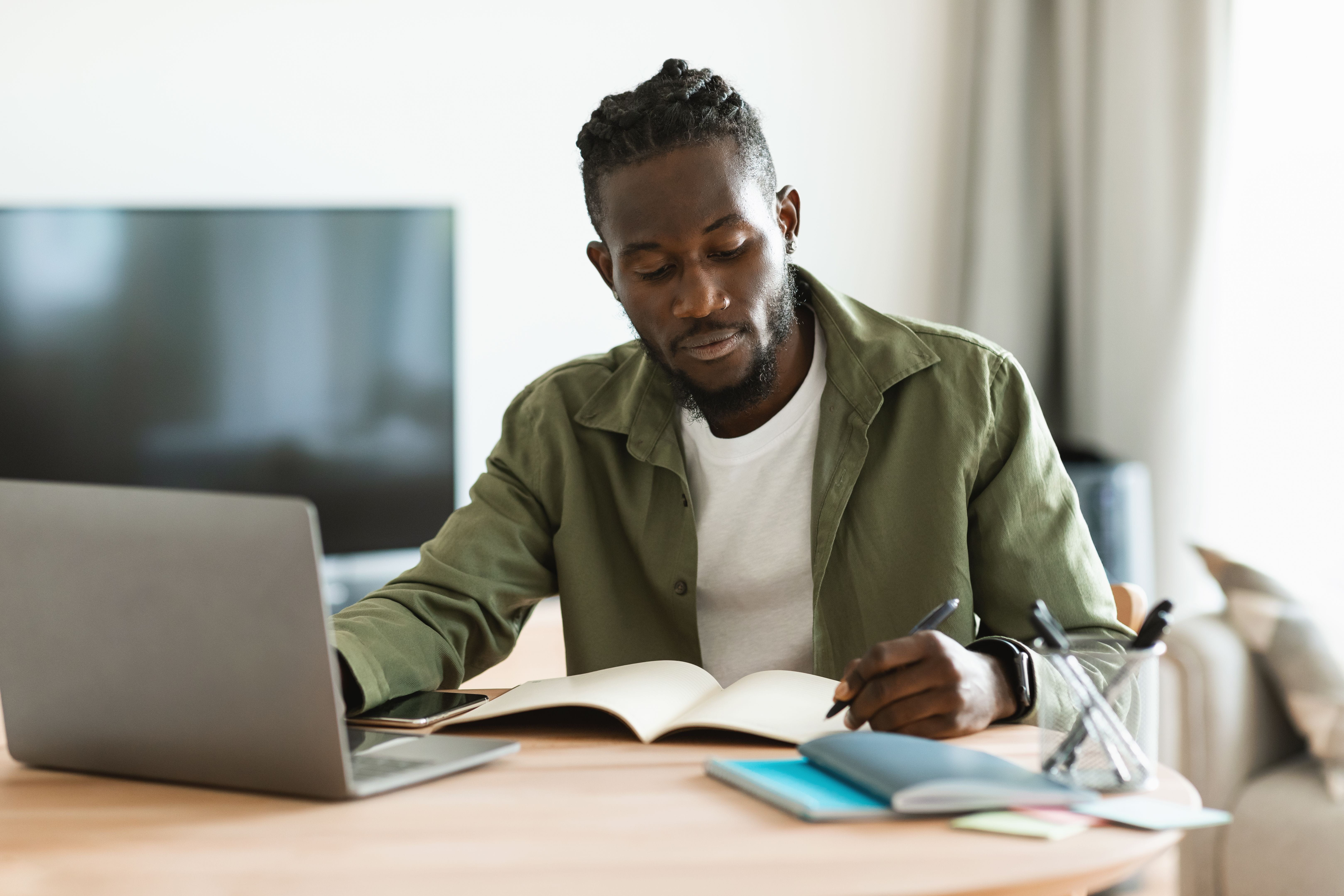 man writing in journal