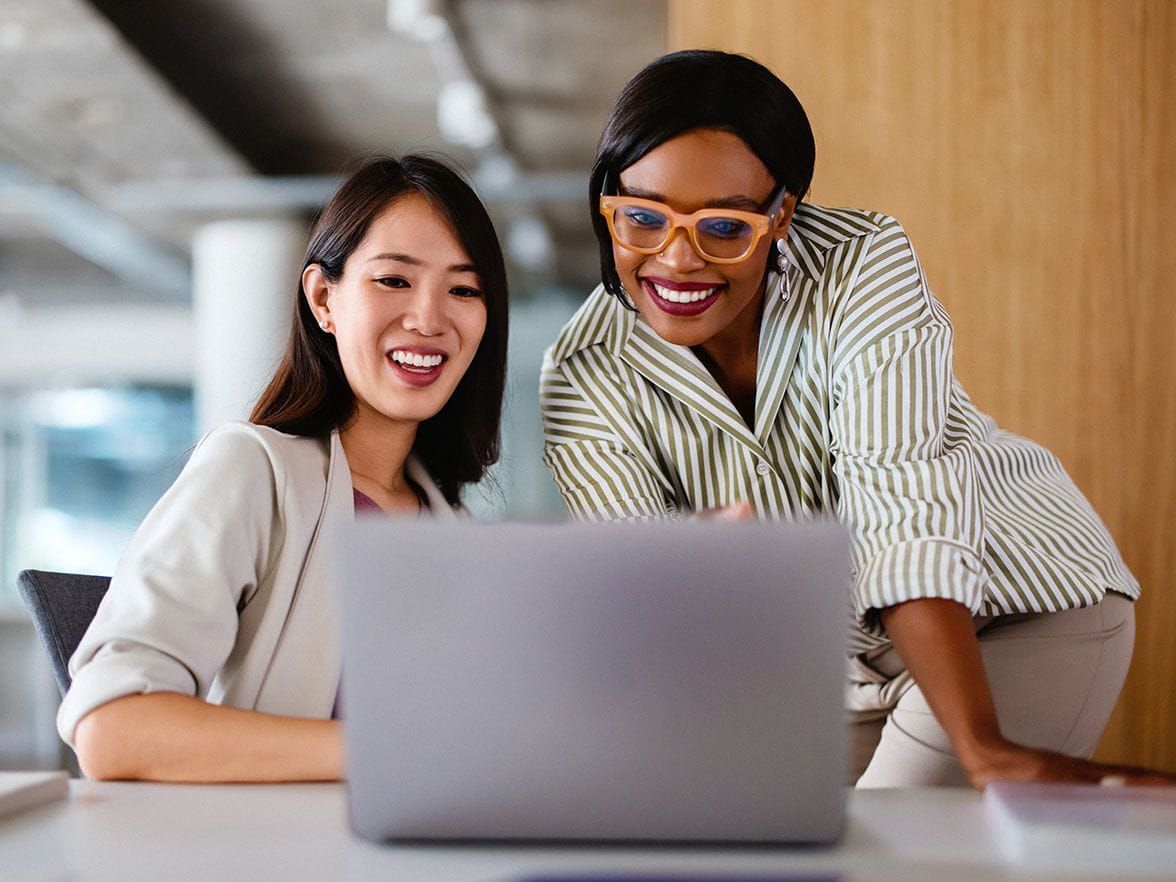 Two working professionals looking at a laptop