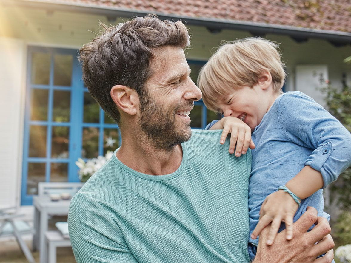 Father holding giggling son