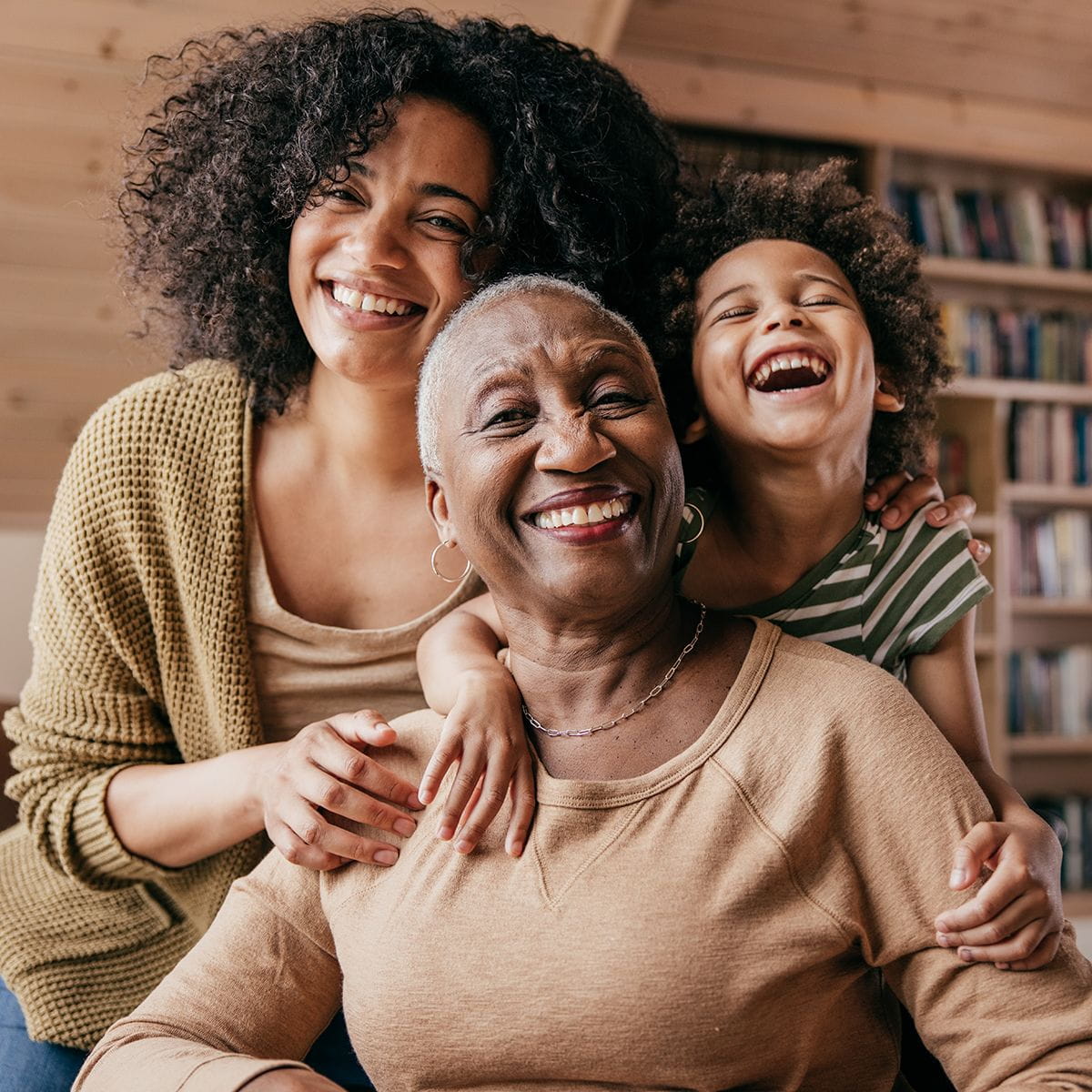 Mother, daughter, and grandmother standing together smiling