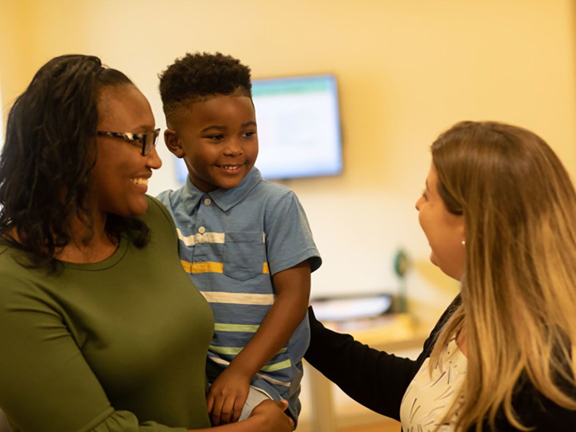 Mom and son talking to his preschool teacher