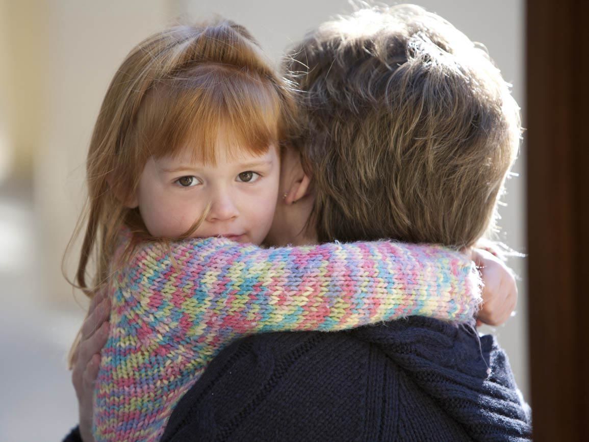 A toddler hugging her parent