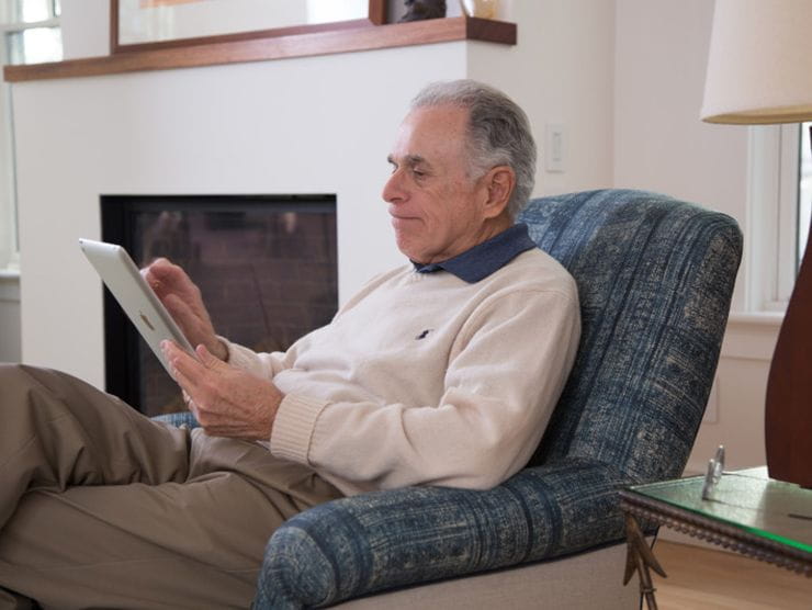 Elderly parent using a tablet to see his family