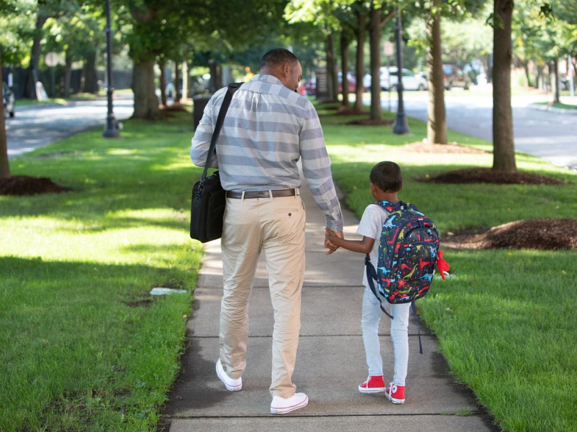 Father and son holding hands walking together
