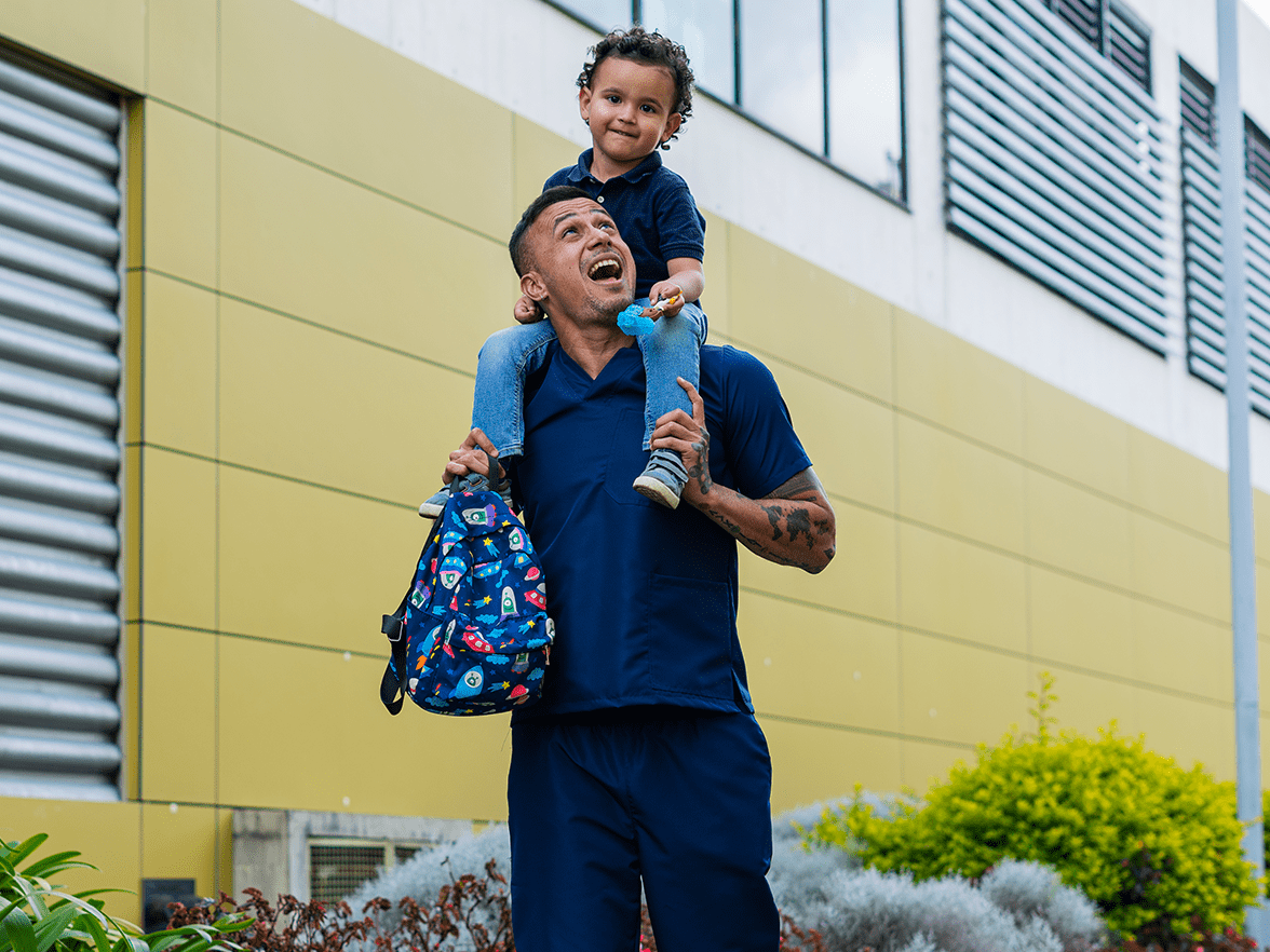 Healthcare worker carrying his son on his shoulders