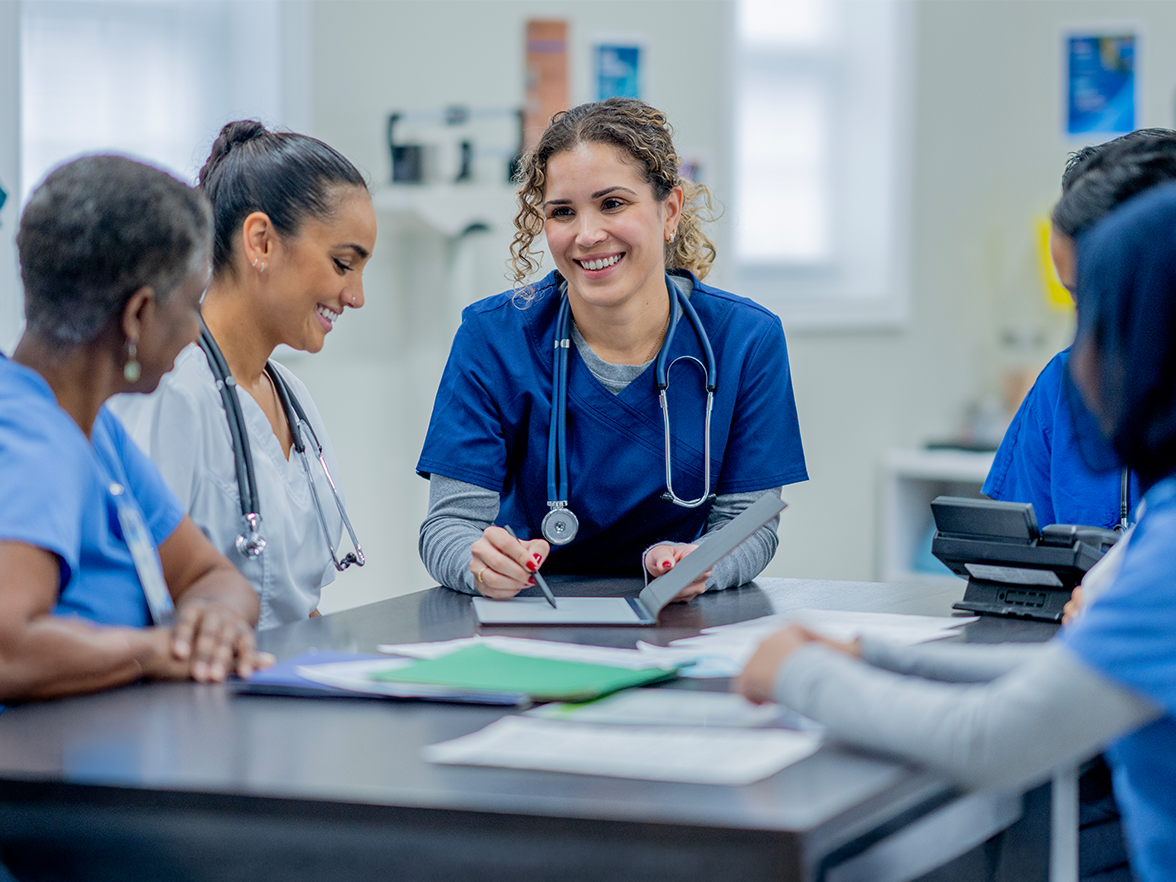 Group of healthcare workers sitting at a table collaborating