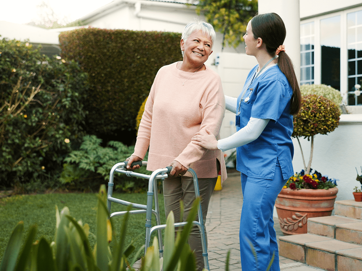 Healthcare caregiver walking with a senior with a walker