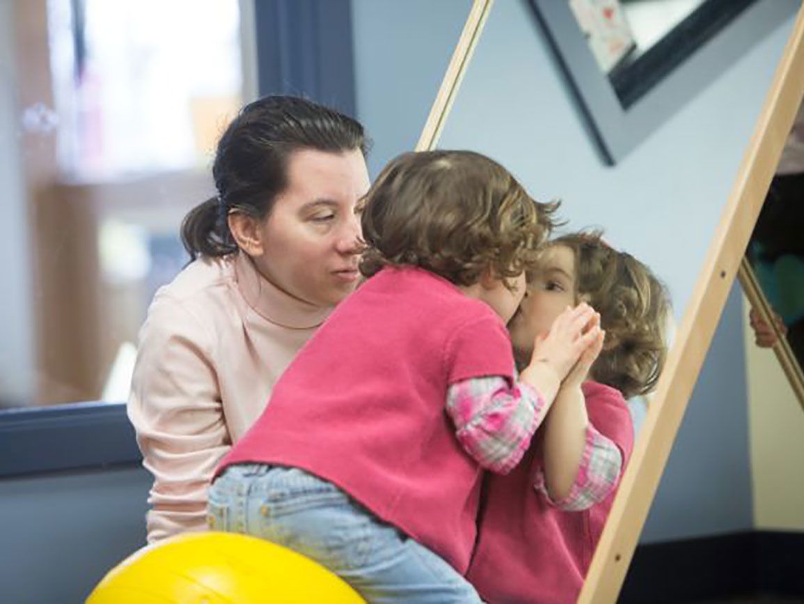 Toddler making faces in the mirror