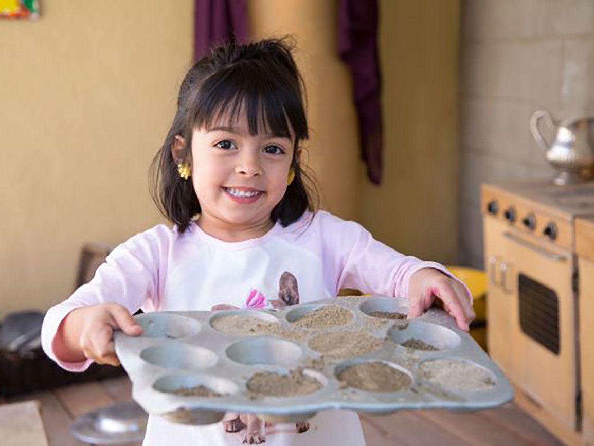 Kindergarten-aged girl carrying a tray