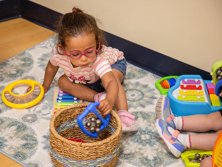 Girl with glasses playing on floor