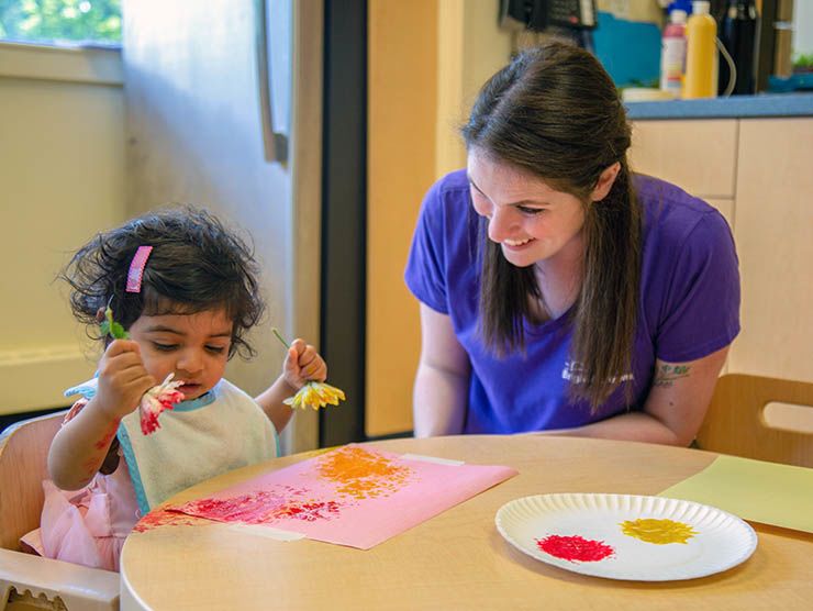 Teacher with toddler painting