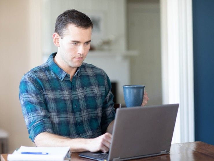 Adult male doing homework on laptop