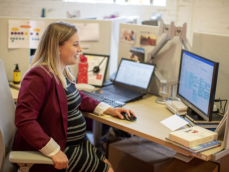 Pregnant employee working at desk