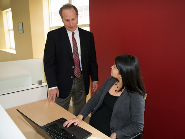 Male employee speaking to pregnant co-worker