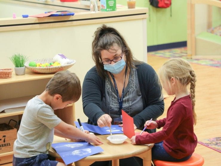 teacher at table with children 