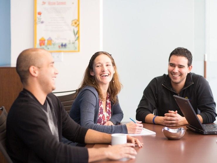 co-workers sitting at table laughing 