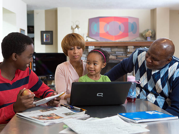 Family around the table, on laptop