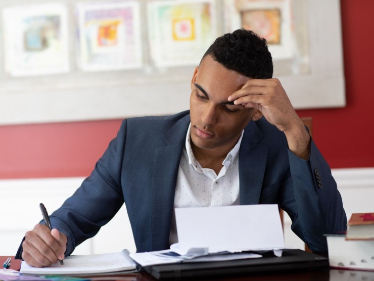 man sitting with notepad at table 