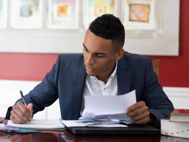 man sitting at table with books 