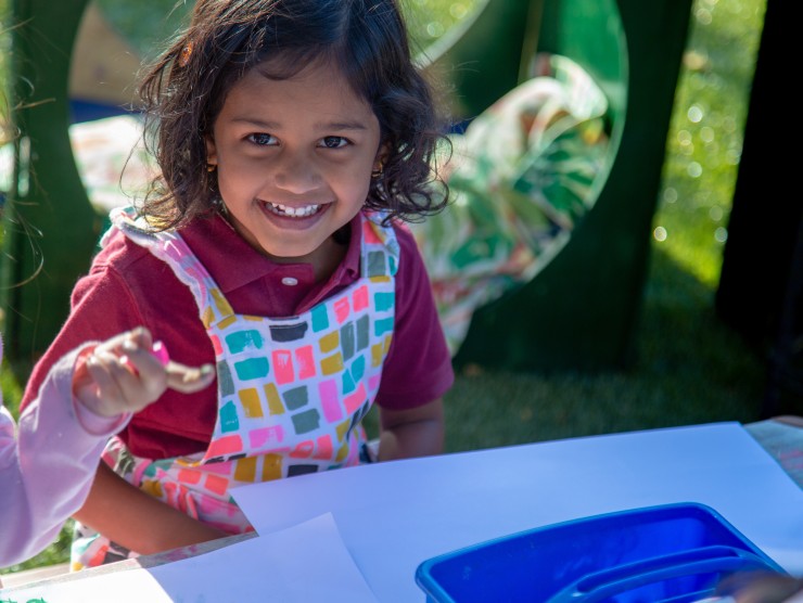 child playing with paint at table 