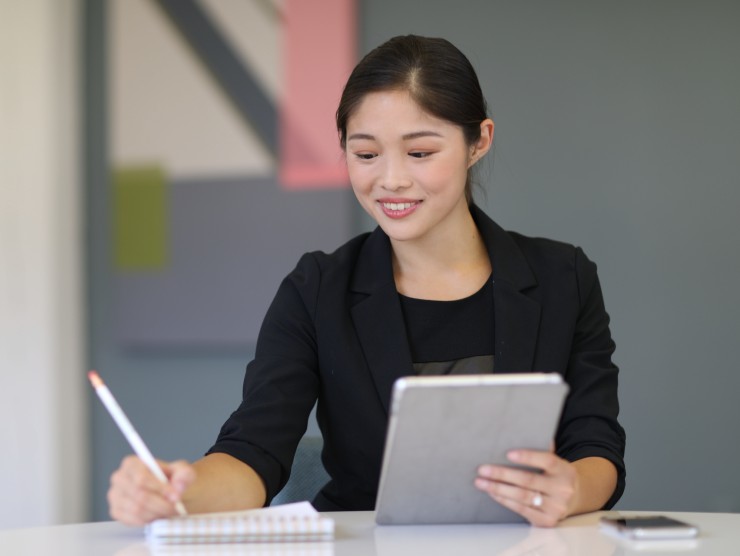 women sitting at table taking notes