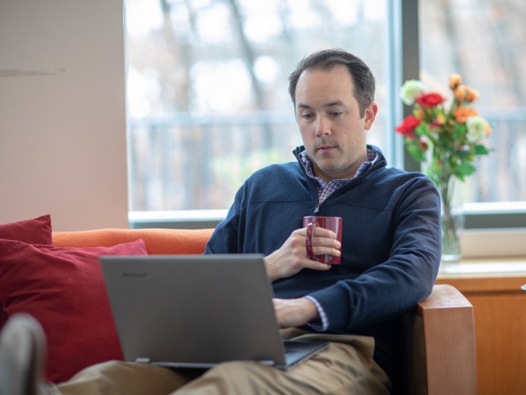 man sitting on couch with laptop 