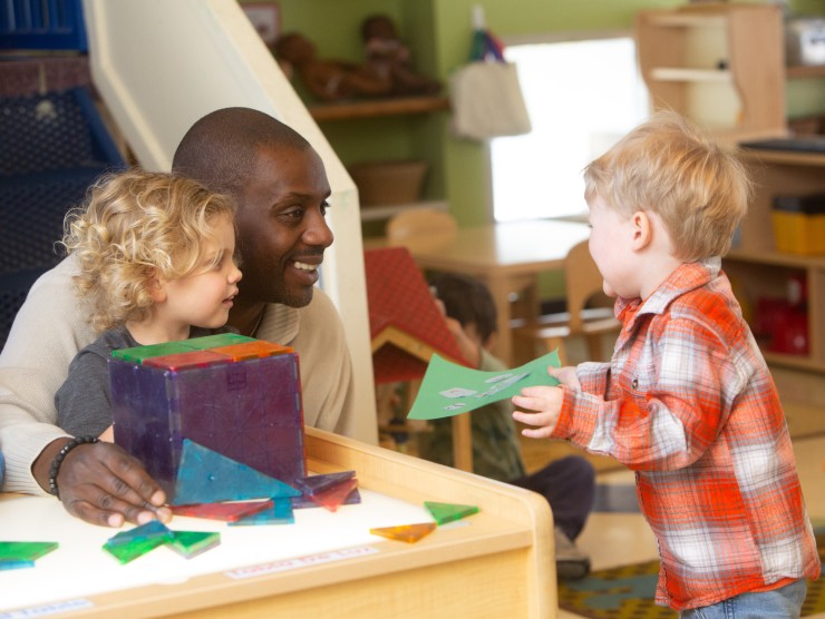 teacher sitting with two children