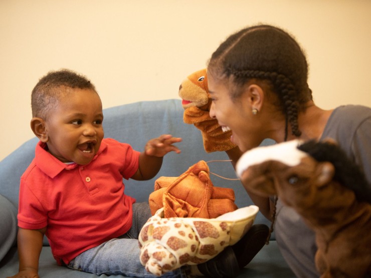 child and teacher playing with puppets