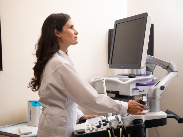 healthcare worker standing at monitor 