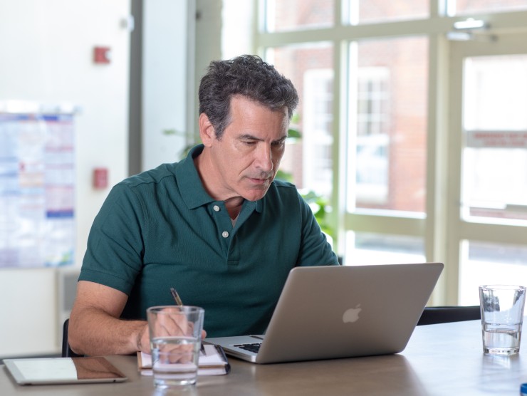 man sitting at counter on laptop 