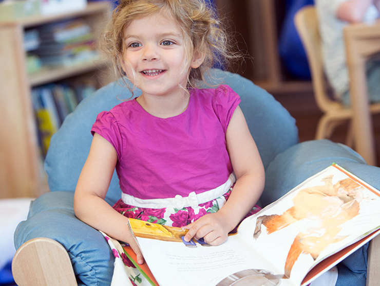 Child reading a book at a NYC Bright Horizons center