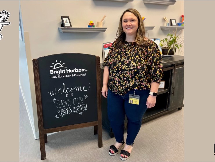 teacher standing in front of sign 