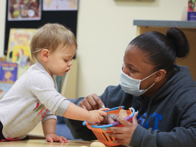 teacher with child playing at table 