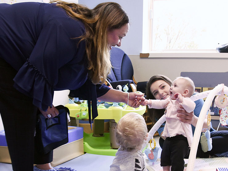 Kendra Kett, division vice president for Bright Horizons, says hello to one of McHenry Childcare Center’s littlest charges in the infant room. The center cares for children from 6 weeks up to 12 years old.