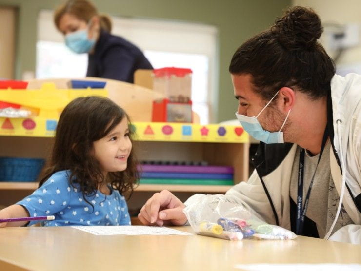 child sitting with teacher