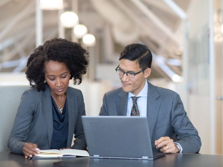 co-workers sitting at table with laptop 